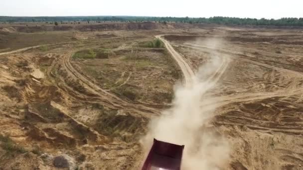 Aérien pour le camion rouge conduisant sur sol sec d'une route de campagne avec forêt de pins verts et ciel bleu sur le fond. Scène. La poussière sèche d'un camion qui se déplace sur une route de campagne . — Video