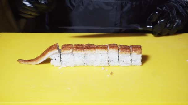 Primer plano del chef sushi preparando los rollos europeos con anguila en una gran mesa de cocina amarilla. Una trampa. Comida tradicional japonesa — Vídeos de Stock