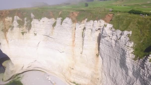 Bílá skála s obloukem a mlhavé pobřeží. Akce. Pohled na malebné panorama pobřežního útesu ponořeného do lehké mlhy v letním dni — Stock video