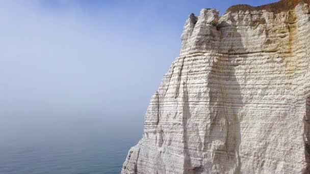 Vista superior de turistas em pé no pico do penhasco branco no mar. Acção. Vistas espetaculares de penhasco branco maciço, mar azul e passear na borda dos turistas — Vídeo de Stock