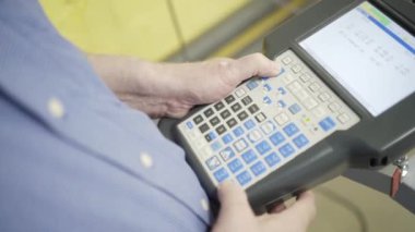 Fabrikada makine kontrol paneli tutan işçinin yakın çekim. Eylem. Fabrikada endüstriyel ekipman modern çok düğmeli kontrol paneli tutan Mens eller