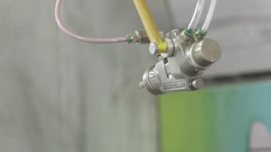 Otomatik üretimde boya ile sprey tabancası. Eylem. Fabrika üretiminde boyama parçaları ile çalışan robot el spreyi ile yakın çekim otomatik. Üretimde otomatik yüksek teknolojiler