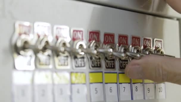 Gros plan du tableau de distribution des fusibles. L'action. Panneau manuel avec interrupteurs à bascule sur fusible d'usine. Main de l'ouvrier de l'usine commute basculer sur la brosse — Video