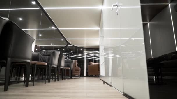 Sillas de negocios y mesas para dos personas en un lujoso restaurante. Acción. Vista inferior del lujoso restaurante moderno con mesas de negocios y sillas de cuero en el interior brillante blanco-negro — Vídeos de Stock