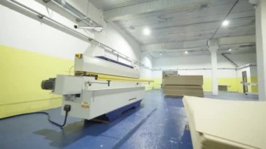 Ahşap işleme makineleri ile oda. Eylem. Endüstriyel işletmede ahşap işleme makineleri ile modern atölye. Modern makineler katlanmış ahşap panoları ile parlak odada