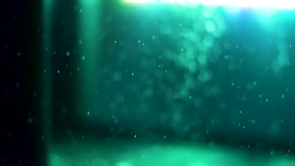 Vista lateral del agua burbujeante con una lámpara verde en el fondo. Una trampa. Burbujas de aire bajo el agua en acuario de peces vacío . — Vídeos de Stock