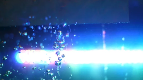 산소 거품, 물 배경의 아름다운 혼란 운동의 측면보기. 프레임. 배경에 물과 밝은 파란색 램프빈 유리 탱크. — 스톡 사진