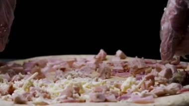 Rendelenmiş peynir, İtalyan gıda kavramı ile pizza serpme pişirme eldiven bir kadın elleri. Çerçeve. Pizzanın üzerine peynir koyan şef elleri için kapat.