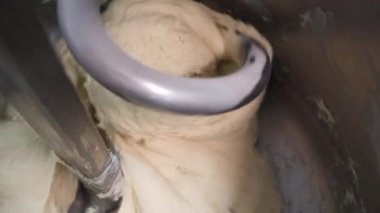 Bir ekmek fırını üretim fabrikasında hamur yoğurması için kapatın. Stok görüntüleri. Ekmek Karıştırıcı Fırında, bir fırın makinesinde bagetler için hamur karıştırma.
