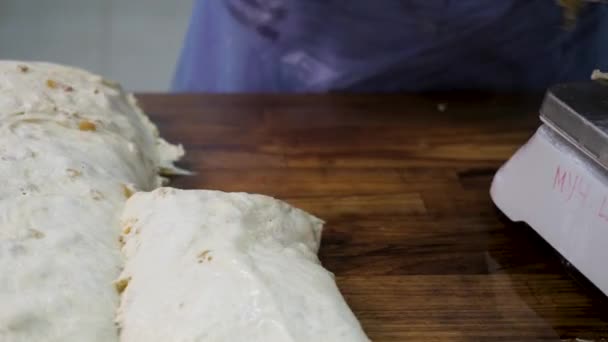 Close-up voor Bakker snijden deeg in stukken voor het koken en wegen ze bij de bakkerij. Stock footage. Vrouw maken van brood stukken van rauw gebak een putting in op de schaal. — Stockvideo