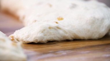 Masanın üzerinde ahşap tahta üzerinde yatan pasta ham parçaları için görünümü kapatın. Stok görüntüleri. Pişirmeye hazır kuru üzümlü geleneksel lezzetli pasta parçaları.