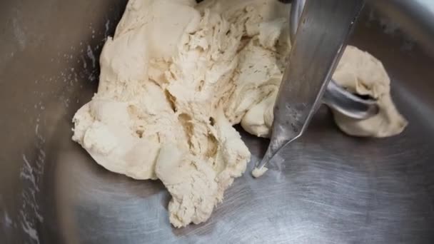 Close up for raw tough in a industrial bakery dough mixer, food concept. Запись. Вид сверху большого стенда, используемого в хлебопекарне для смешивания хлебного теста . — стоковое видео