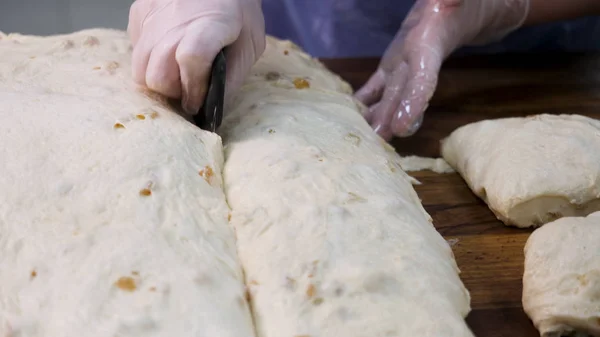 Närbild för Baker skära degen i bitar innan tillagning och vägning dem på bageriet. Stock film. Kvinna som gör brödbitar från rå bakverk en sätta in på skalan. — Stockfoto