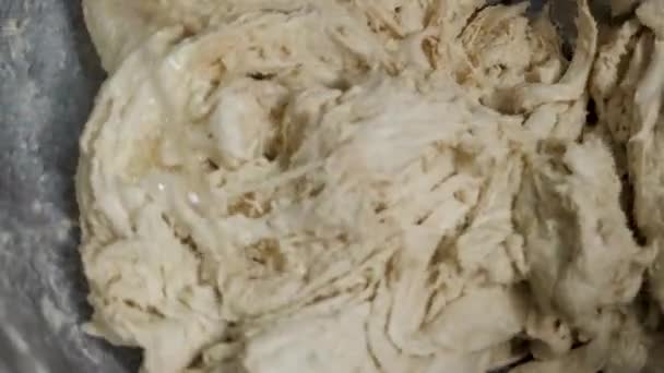 Fermer pour la pâte dans le mélangeur électrique et l'huile de graine étant mis dans la cuve métallique. Images d'archives. Le processus de mélange de la pâtisserie et de l'huile liquide à l'usine .