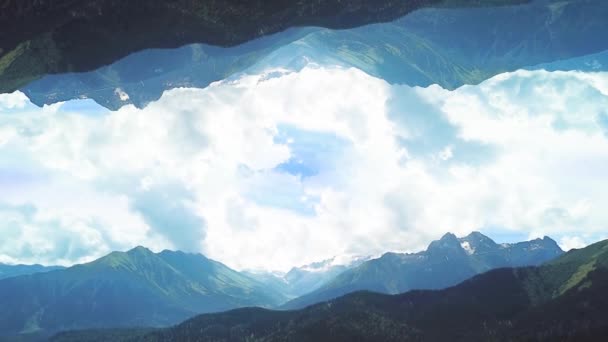 Ayna görüntüsü efektli dağların panoraması. Atış. Ters dünyanın ayna etkisi ile arka plan mavi bulutlu gökyüzü üzerinde dağların yeşil vadilerin Güzel üst görünümü — Stok video