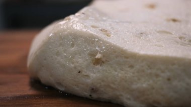 Close-up of dough pieces with yellow raisin laying on the wooden board on the kitchen. Stock footage. Easter cakes making