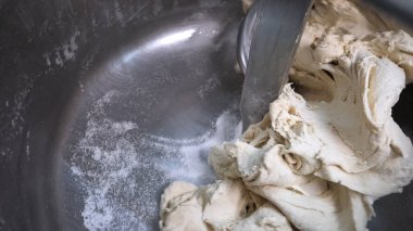 Fırının mutfağındaki ya da imalatındaki profesyonel bir yoğurucu makinesinde pişirilen hamur işleri için yakın çekim. Stok görüntüleri. Hamur yapma süreci