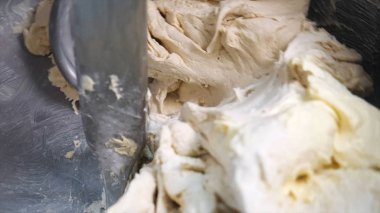 Un ve diğer malzemeleri fırın mutfağında ya da imalatta profesyonel bir yoğurucu makinesinde karıştırmaya yakın çekim. Stok görüntüleri. Hamur yapma süreci