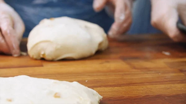 Cuisinière dans des gants et tablier bleu préparant des morceaux de pâte pour la cuisson dans une boulangerie. Images d'archives. Concept boulangerie et produits du pain — Photo