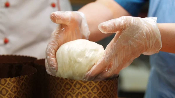 Крупним планом руки пекаря в силіконових рукавичках замішують шматочок тіста, щоб зробити деякі випічки. Стокові кадри. Робітники в пекарні — стокове фото