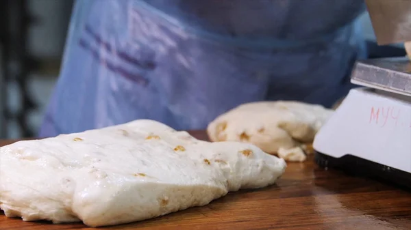 El primer plano de las manos del panadero en guantes usando utensilio de cocina y cortar una masa en la cocina en la panadería. Imágenes de archivo. Productos horneados preparación — Foto de Stock