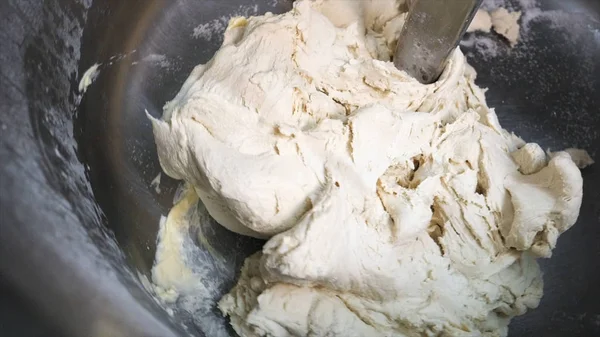 Close-up of dough for baking of baked goods in a professional kneader machine in kitchen of bakery or at the manufacturing. Stock footage. Dough making process — ストック写真
