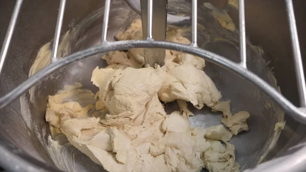 Close-up of baker's hand adding a bit of creamery butter to other ingredients in a professional kneader machine in kitchen of bakery or at the manufacturing. Stock footage. Dough making process — ストック写真