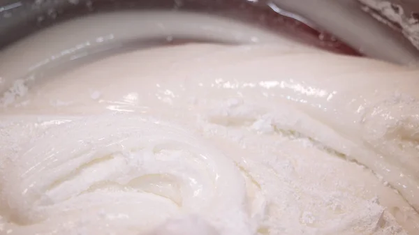 Close-up da mão do padeiro misturando creme de ovo para pastelaria em uma tigela grande. Imagens de stock. Cozimento de bolo — Fotografia de Stock