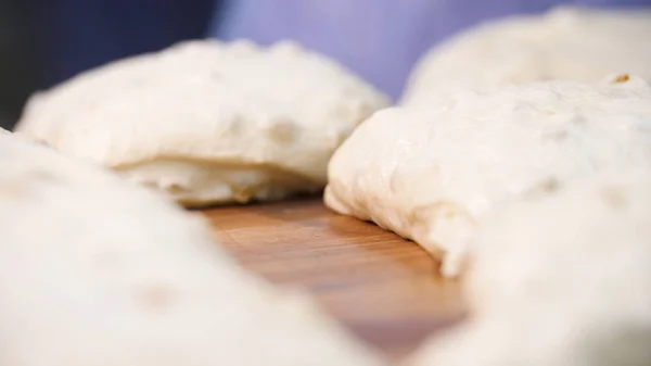 Närbild för råa bitar av konditorivaror som ligger på trä ombord på bordet. Stock film. Traditionella läckra bakverk bitar med russin redo för bakning. — Stockfoto