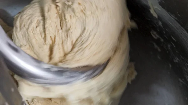 Processo de preparação de massa de pão usando a máquina de mistura de farinha na fábrica. Imagens de stock. Close-up para massa crua a ser amassado na fabricação, conceito de alimentos . — Fotografia de Stock