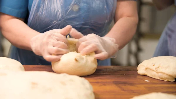 Kvinna i matlagningshandskar knåda deg på träskiva, matlagning koncept. Lagerbilder. Närbild för händer gör bakverk för bröd bakning. — Stockfoto