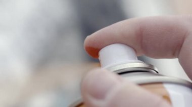 Boya dan sprey parmakları yakın çekim. Eylem. Sokak sanatı sanatçısı sprey boya şişesi ile çizer. Sokak boyama sanatı. Sanat yaratma sürecinde sanatçı