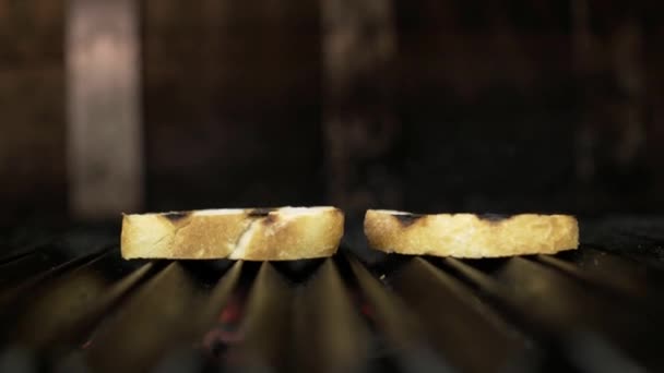 Primo piano di due fette di pane alla griglia. Azione. Fette di pane semplici fragranti fritte in forno su griglia. Toast al forno grill per una colazione semplice e perfetta — Video Stock