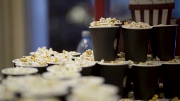 Muchas tazas de palomitas en el cine. Acción. Deliciosas palomitas frescas fragantes cocinadas antes de la película en el cine. La noche en el cine no puede ser buena sin palomitas de maíz — Vídeo de stock