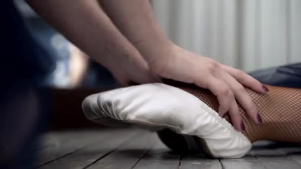 Zblízka roztahuje baletky na podlahu. Akce. Uzavření roztáhnutí ponožek na špičkové boty pro zahřátí před tréninkem v taneční hale — Stock video