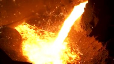 Erimiş çelik, daha fazla işlem için fırından çelik fabrikasında kepçe olarak aktarılır. Stok görüntüleri. Metalurji fabrikasında çelik eritme detayları.