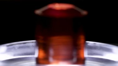 Siyah arka planda Petri çanak yatıyor güzel kırmızı taş. Stok görüntüleri. Cam stand üzerinde yatan yakut renk kristalleri için yakın, Jeoloji kavramı.