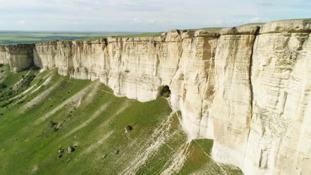 Impresionante paisaje de White Rock en Crimea con prado verde brillante a los pies. Le dispararon. Aérea para la hermosa montaña con la cima plana y el campo verde sobre el fondo nublado del cielo . — Vídeo de stock