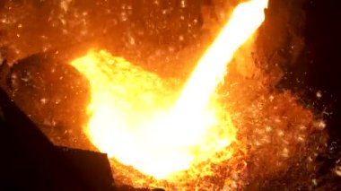 Erimiş çelik, daha fazla işlem için fırından çelik fabrikasında kepçe olarak aktarılır. Stok görüntüleri. Metalurji fabrikasında çelik eritme detayları.