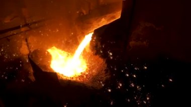 Sıcak çelik, ağır sanayi dökme sürecinde siyah arka planda kıvılcımlar. Stok görüntüleri. Patlama fırınından akan IİD Metal için yakın.