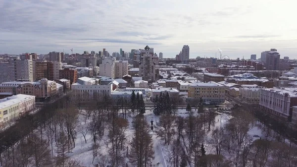 Binalar, parklar ve yollar ile kış şehir manzarası havadan görünümü. Klip. Gri bulutlu gökyüzü arka plan üzerinde karla kaplı çatılar ile şehrin Drone görünümü. — Stok fotoğraf