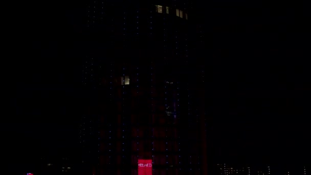 Primer plano para rascacielos modernos por la noche con muchas pequeñas luces brillantes, concepto de vida nocturna. Acción. Aérea para el edificio de fachada de vidrio sobre fondo de cielo negro . — Vídeo de stock