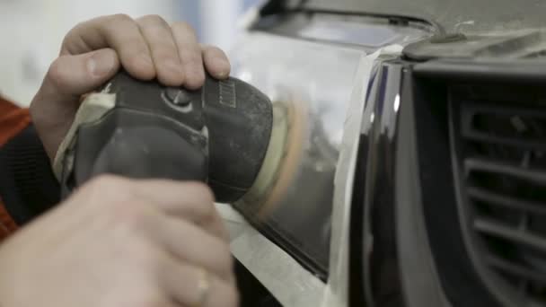 Cierre para el pulido mecánico automático y el pulido de la cabeza del coche. Luz. Art. Trabajador pulir el faro de un coche en la reparación del automóvil y renovar la estación de servicio, utilizando una máquina de amortiguación de potencia profesional — Vídeo de stock