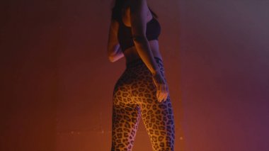 Spor tozluk poz güzel modelin arka görünümü. Eylem. Neon ışıkla aydınlatılan spor tozluklarda güzel model