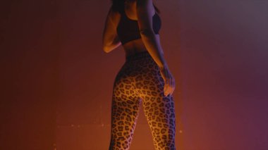 Spor tozluk poz güzel modelin arka görünümü. Eylem. Neon ışıkla aydınlatılan spor tozluklarda güzel model