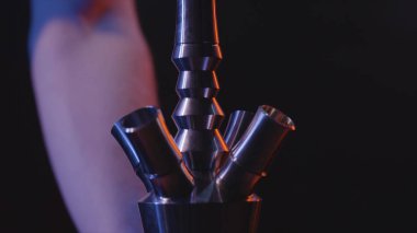 Nargilenin yakın çekim detayları. Eylem. Erkek elleri siyah izole arka plan üzerinde nargile tabanının ayrıntıları toplamak ve büküm