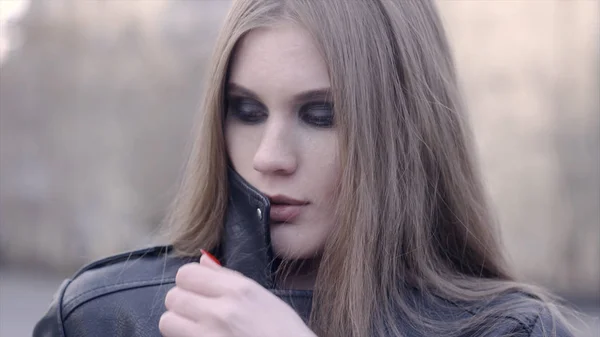 Mujer con estilo mirando a la cámara al aire libre en la calle. Acción. El rostro de una joven satisfecha en la ciudad — Foto de Stock