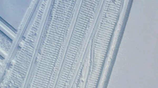 Tracks left by snowmobiles in snow. Footage. Top view on clear footprints in white snow left by snowmobilers. Winter mode of transport — Stock Photo, Image