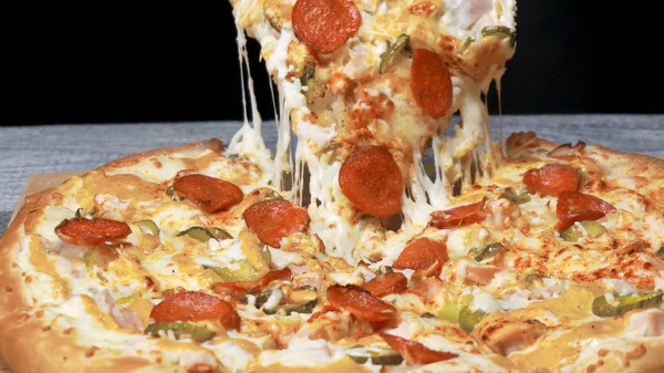 Tasty take slice of pizza with cheese. Frame. Appetizing separate piece of round pizza stretching melted cheese. Juicy pizza from behind which will flow salivating — Stock Photo, Image