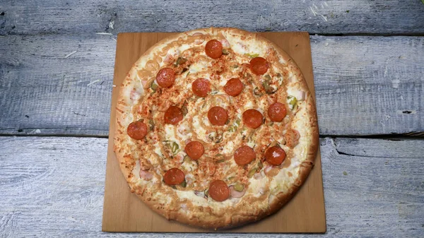 Вкусная свежеиспеченная пицца на деревянном подносе. Рамка. Сочная аппетитная пицца на деревянном подносе, профессионально запечённая пицца готова к употреблению — стоковое фото